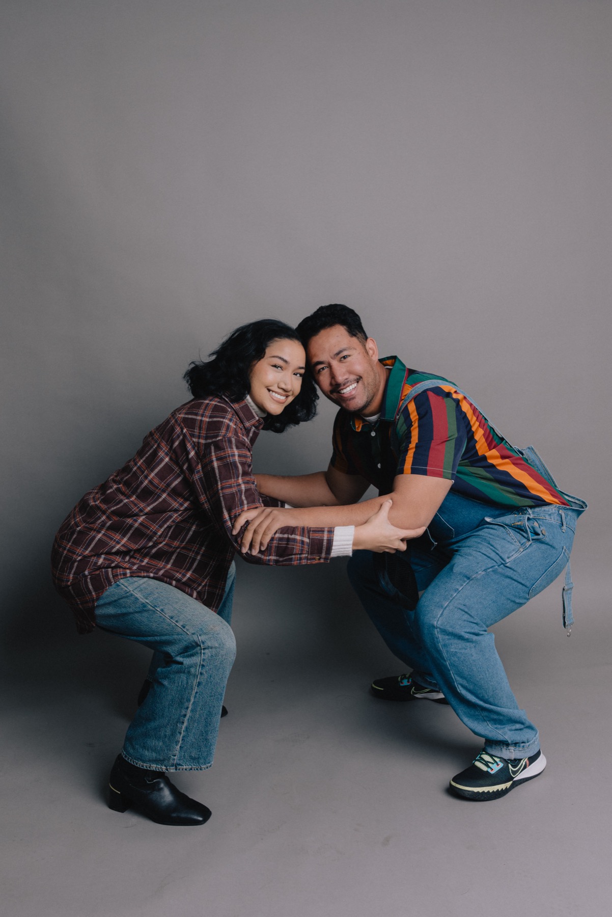 Couple posed together in a 90s-inspired studio portrait