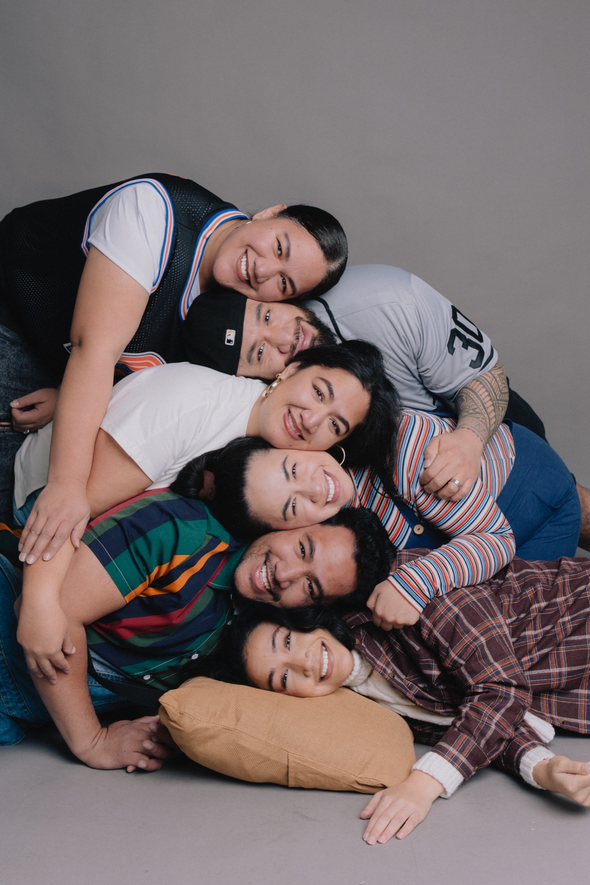 Family members stacked playfully in a studio portrait