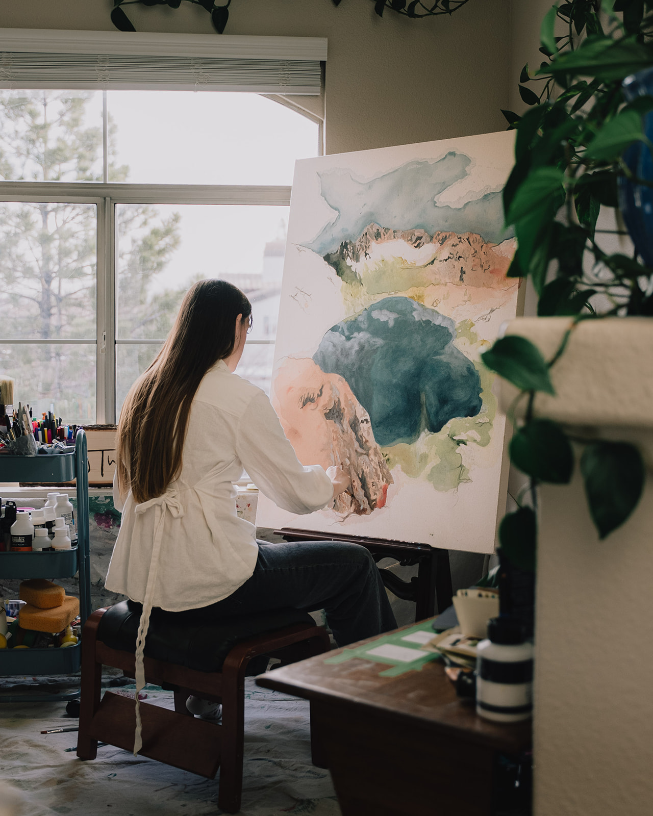 Haley painting a landscape canvas in her Reno studio