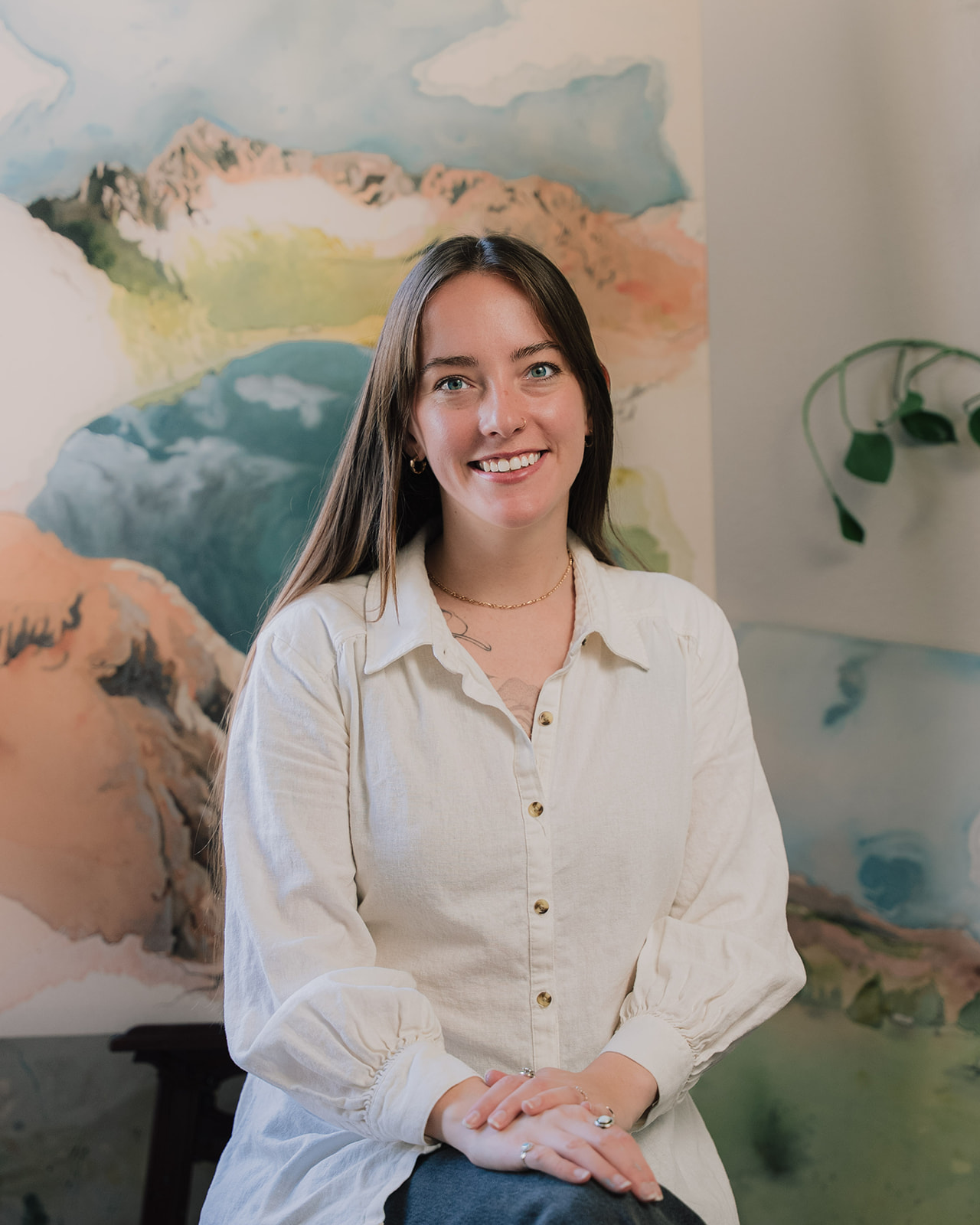 Haley beside a landscape painting in her studio