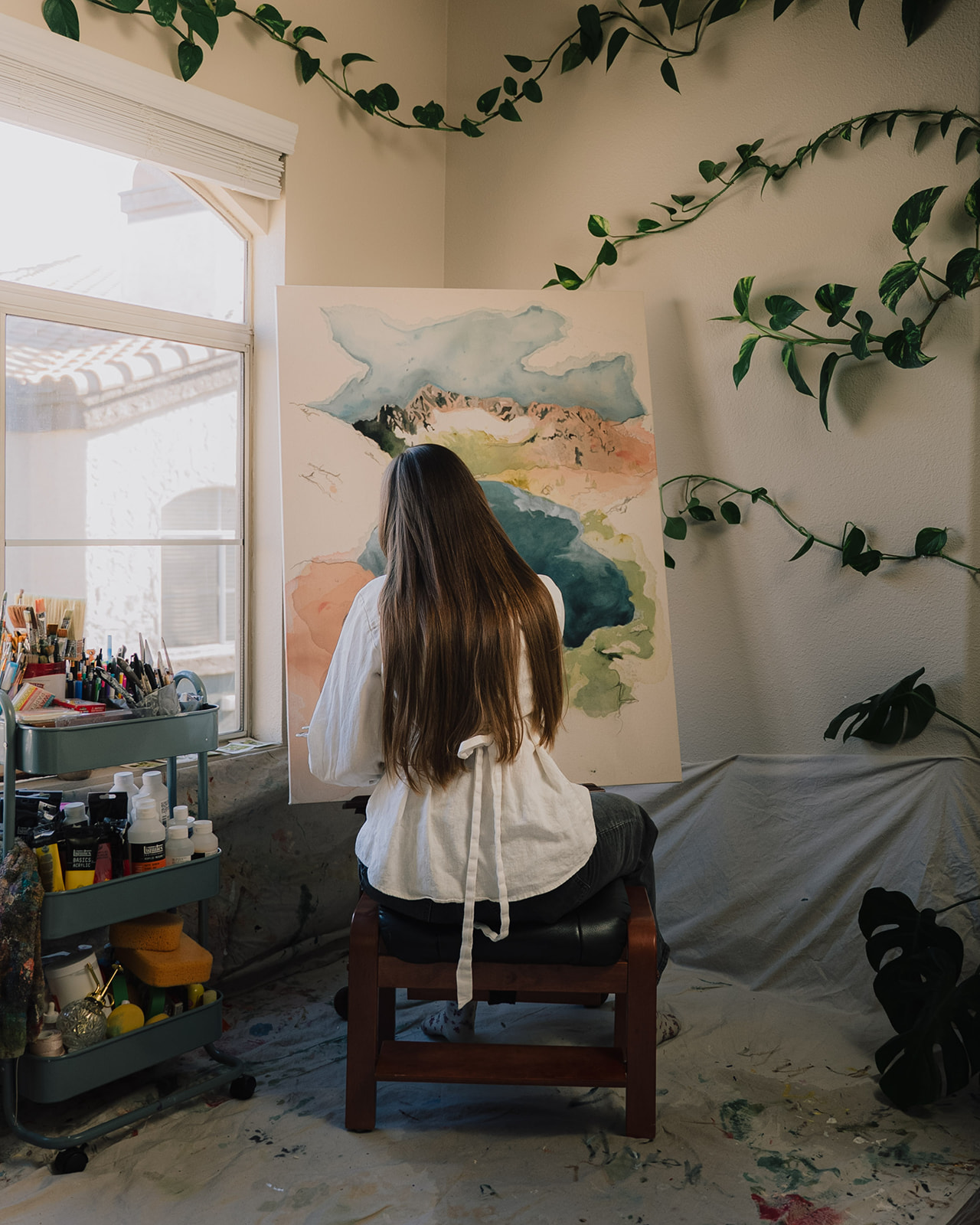 Haley working on a landscape painting in her studio